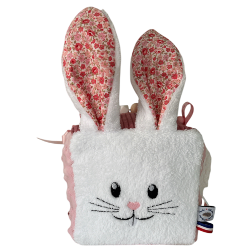 cube d'activité sensoriel pour bébé fille de couleur rose vec lapin blanc et diférentes activités sonores