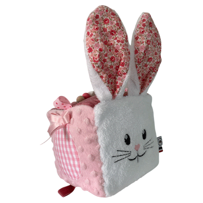 cube d'activité sensoriel pour bébé fille de couleur rose vec lapin blanc et diférentes activités sonores